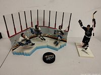 Overall view of diorama with three player figures, separate Kings figure, and signed puck