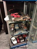 Cabinet shelves holding multiple diecast vehicles
