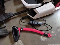 Close-up of charger and red steering handle next to kart frame