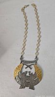 Full view of necklace showing pendant and disc-link chain