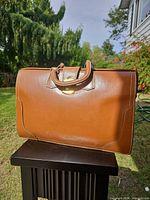 Front view of leather briefcase showing color, stitching, handle, clasp