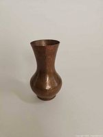 Full view of hammered patinated copper vase upright