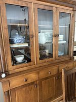 Front view showing upper glass doors and lower drawers/doors
