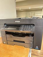 Front view showing Epson branding, control panel, paper trays
