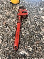 Full view of red Ridgid pipe wrench on countertop