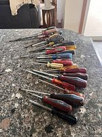 All 17 screwdrivers laid out showing variety of sizes and handle colors