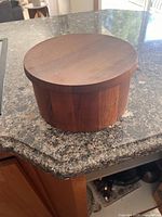 Closed teak ice bucket on countertop