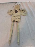 Front view of wooden angel door hanger with sentiment text and wire hanger