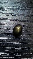 Front view of oval black star sapphire showing 6-ray star