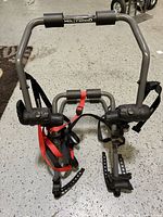 Front view of folded Hollywood Racks trunk bike rack showing frame, cradles, and straps