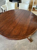 Top view of round wooden dining table showing dark brown plank surface