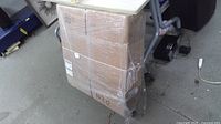 Shrink-wrapped bundle of flat cardboard boxes on dolly