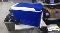 Full side view of blue Igloo cooler showing wheels and pull handle