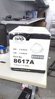 Front of sealed master carton showing SAG logo, part number 8617A, and quantity 12 boxes of 20 masks
