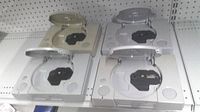 Top view of four PlayStation consoles, two lids open