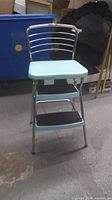 Front view of Cosco turquoise step stool chair showing seat, backrest and steps