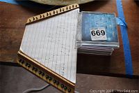 Wooden Music Maker stringed instrument with music sheet and stacked CDs.