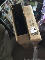 Cardboard box containing the two black folding stools, labeled with dimensions 15X3.5X29