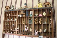 Full front view of the wooden printer's tray with assorted animal and character figurines placed in compartments. Shows the style, layout and contents.