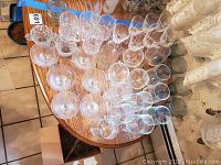 Top view of assorted glassware on table, showing cut glass goblets, mugs and various glasses arranged in rows.
