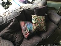 Top view showing the dark plaid couch with multiple pillows including a floral patterned one, showing the overall fabric and cushions.