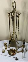 All items grouped: fireplace tool set on stand, chamberstick, urn candlestick, easels, snuffer, rod