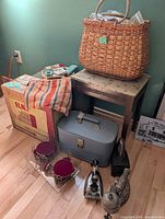 Overall lot showing wicker basket, stool, Elna box, vanity case, irons, miniature furniture on tray