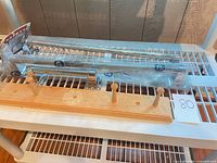 Overview of two long grab bars (one packaged), one shorter grab bar and wood peg rack on shelf