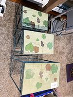 Three nesting tables stacked, showing tile tops and metal frames