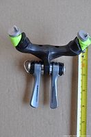 Full view of both Shimano shifters installed on Scott tri bar attachment with ruler for scale