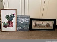 Group shot of three wall art pieces leaning against wall