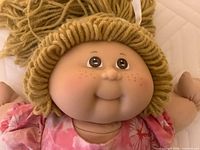 Close-up of doll’s face showing yarn hair and facial features
