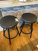 Both gray vinyl swivel bar stools side by side