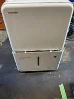 Front view of Toshiba dehumidifier showing overall appearance and water-level window