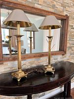 Pair of brass buffet lamps with shades on console table