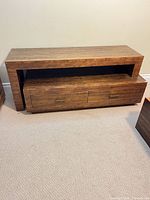 Front view of solid wood media console showing open shelf and two drawers