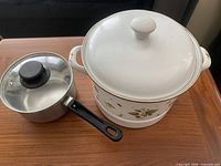 Asahi Horo enamel stock pot with lid beside stainless saucepan with glass lid