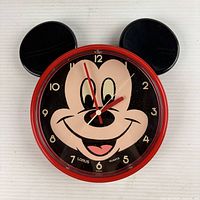 Front view of red Lorus Disney Mickey Mouse wall clock with ear attachments