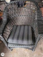 Front angled view showing entire wicker armchair and seat cushion