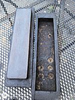 Stone removed from open wooden box showing interior