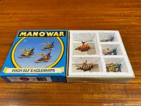 Open box with foam insert and three painted Eagleship miniatures