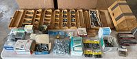 Overview of entire lot on table with wooden organizer trays and boxed hardware