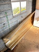 Stack of corrugated polycarbonate panels leaning against wall