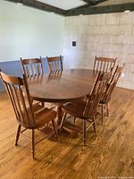 Oak dining table with six chairs in room