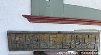 Front view of carved wooden "EAGLE LION" sign showing weathered surface and lettering