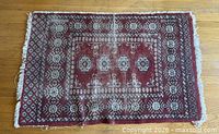 Full view of Persian-style rug showing design, wear, and fringe