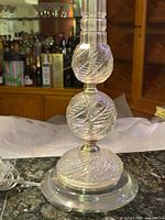 entire lower half of crystal lamp showing round base, two cut crystal orbs, cord