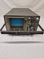 Front view of Hewlett-Packard 1740A oscilloscope showing CRT screen, controls and rack frame