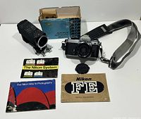 Group shot of Nikon FE camera with lens, Soligor bellows, box and literature