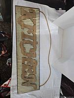 Front view of metal and wood kitchen sign showing lettering and rope hanger
